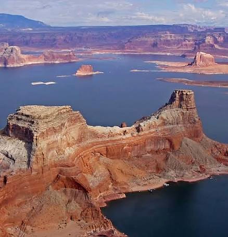 Aerial view of Lake Powell with red sandstone buttes rising from deep blue canyon water